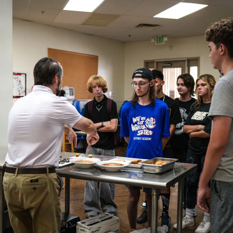 A Gateway teacher walks students through dishes from around the world during a Global Partnerships food tasting