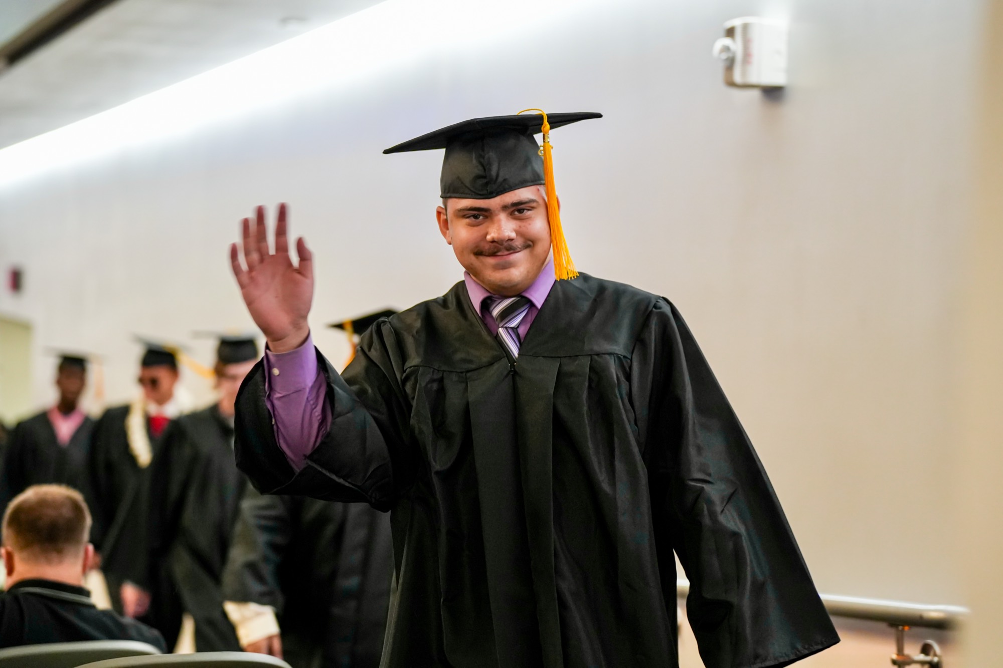 Gateway graduate waving during commencement